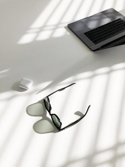 wayfarer风格太阳镜和MacBook Pro的平面摄影